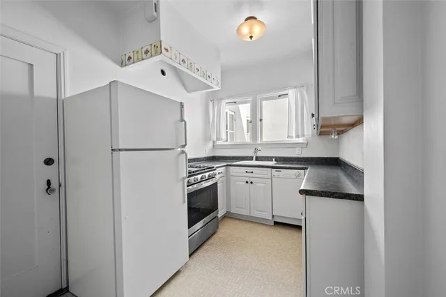 a kitchen with a refrigerator sink and cabinets