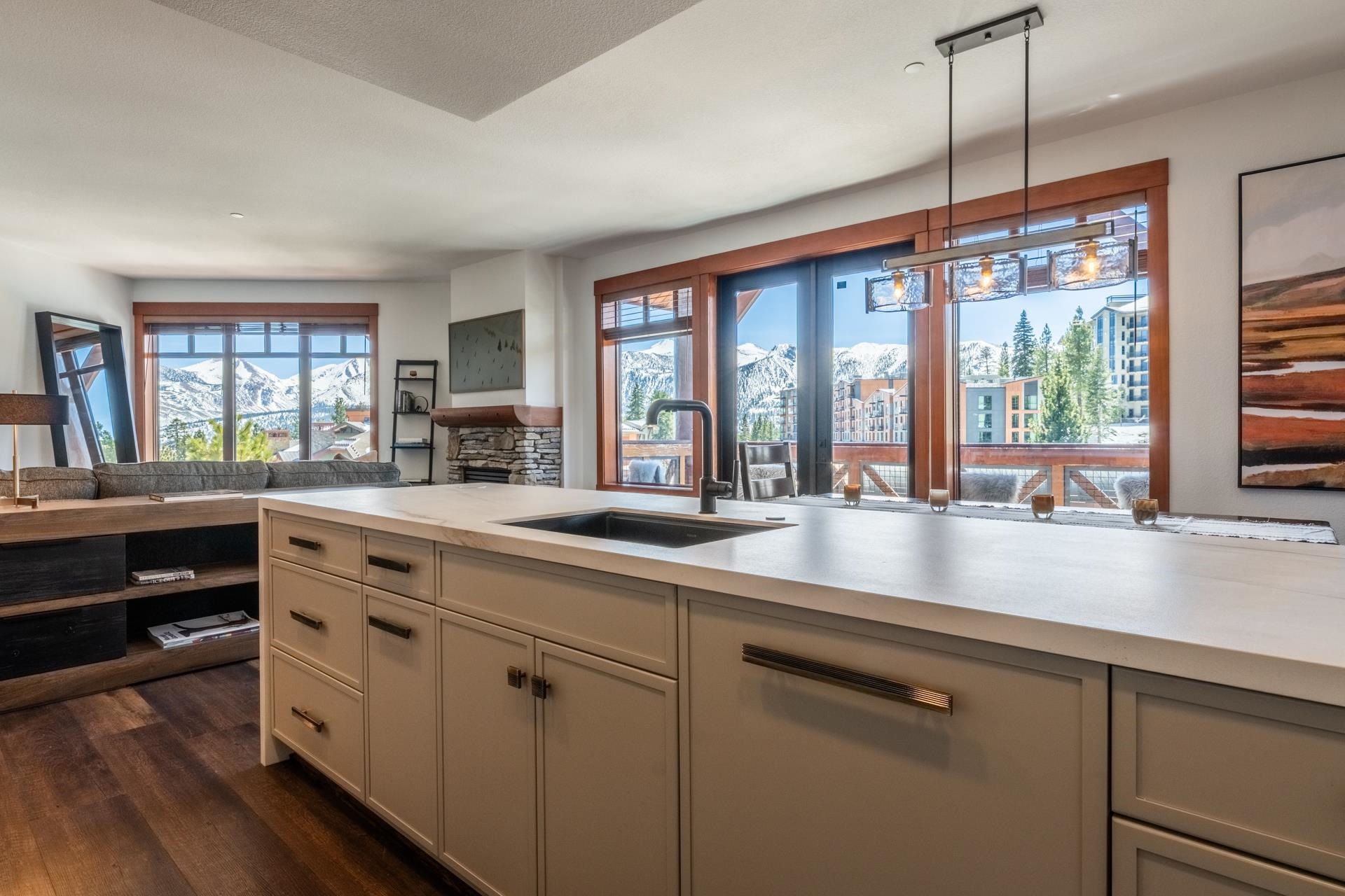 Kitchen island featuring a dark sink basin, matte black faucet, and light-toned countertop