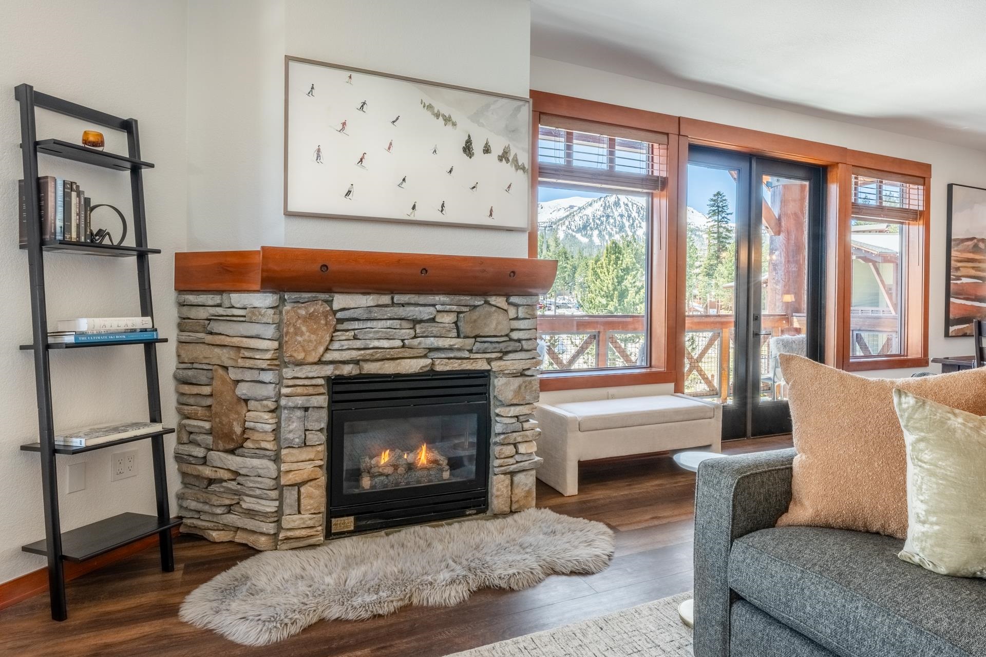 6201 Minaret Road, Unit 2430 Mammoth Lakes, CA 93546 - Photo 13 of 44 Stone-clad fireplace with a prominent wood mantel, framed by wood-finish flooring