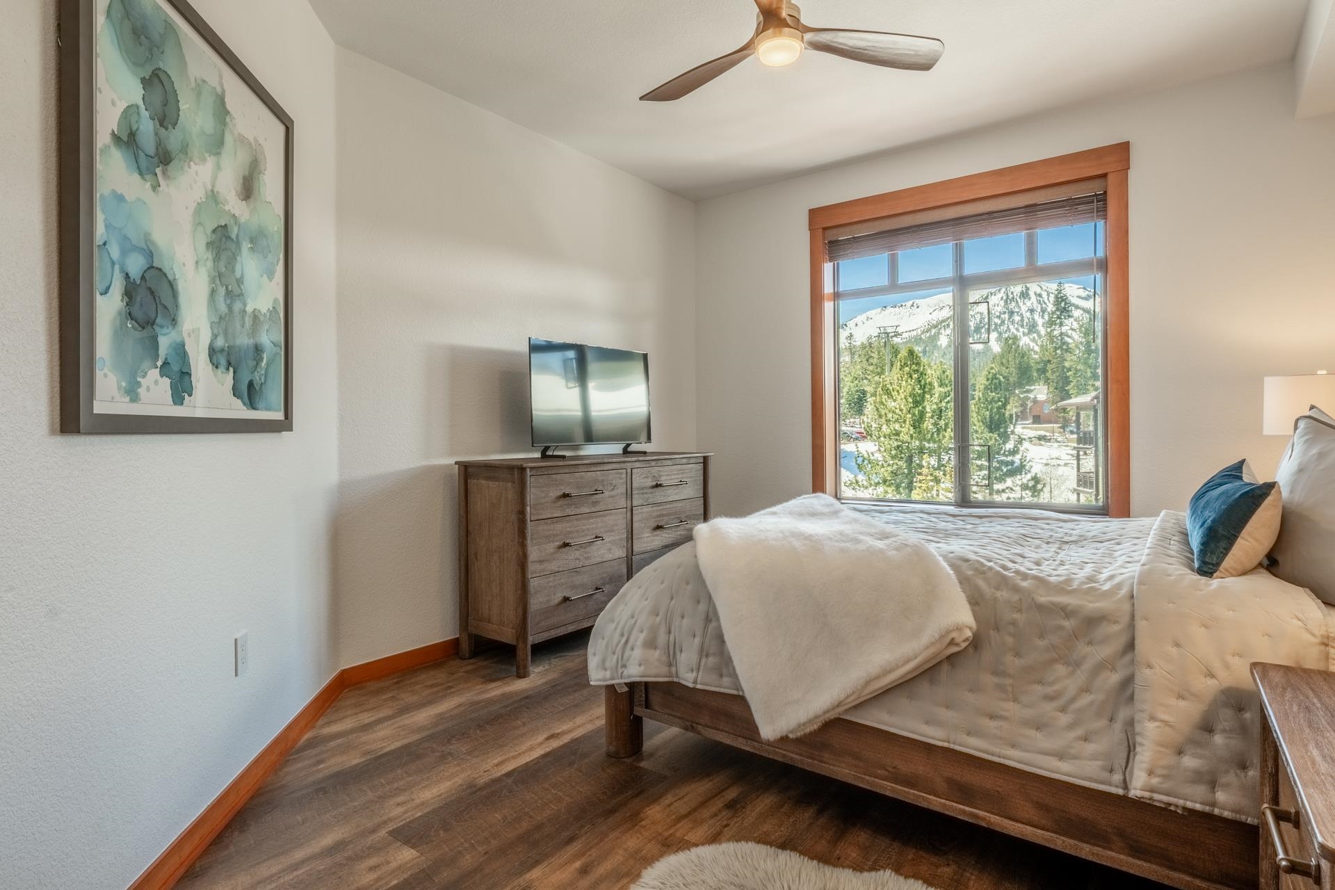 6201 Minaret Road, Unit 2430 Mammoth Lakes, CA 93546 - Photo 24 of 44 Bedroom featuring a large window with natural wood trim, showcasing a mountain backdrop