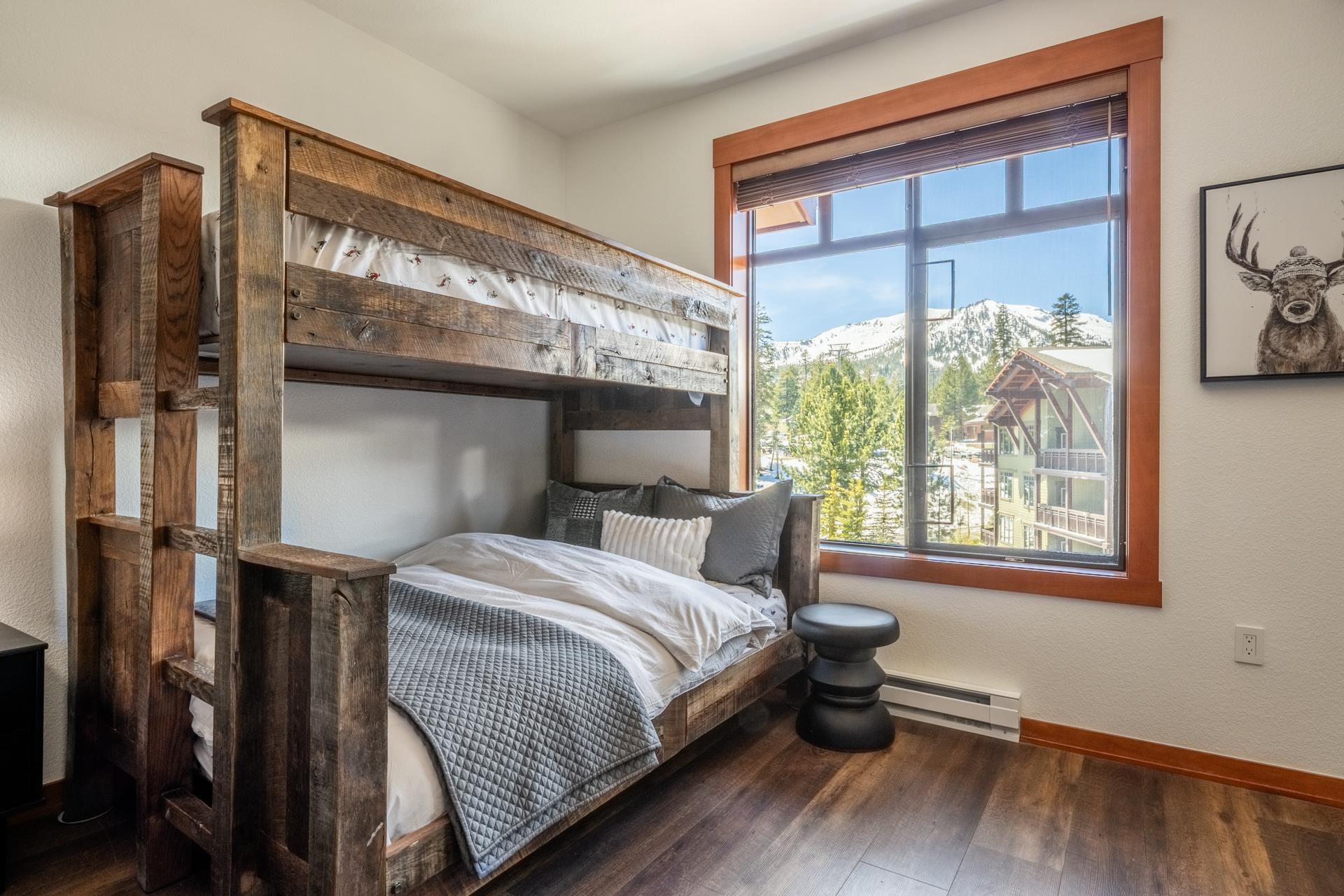 6201 Minaret Road, Unit 2430 Mammoth Lakes, CA 93546 - Photo 30 of 44 Bedroom featuring a large window with wooden trim, wood-finish flooring, a rustic wood headboard, an