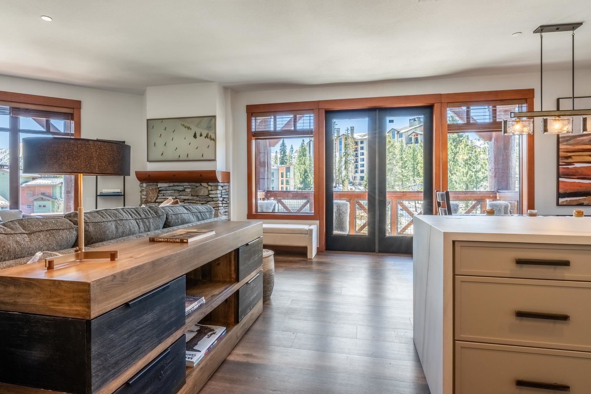 6201 Minaret Road, Unit 2430 Mammoth Lakes, CA 93546 - Photo 7 of 44 Open-concept living area featuring wood-finish flooring, a stone fireplace, and large windows with n