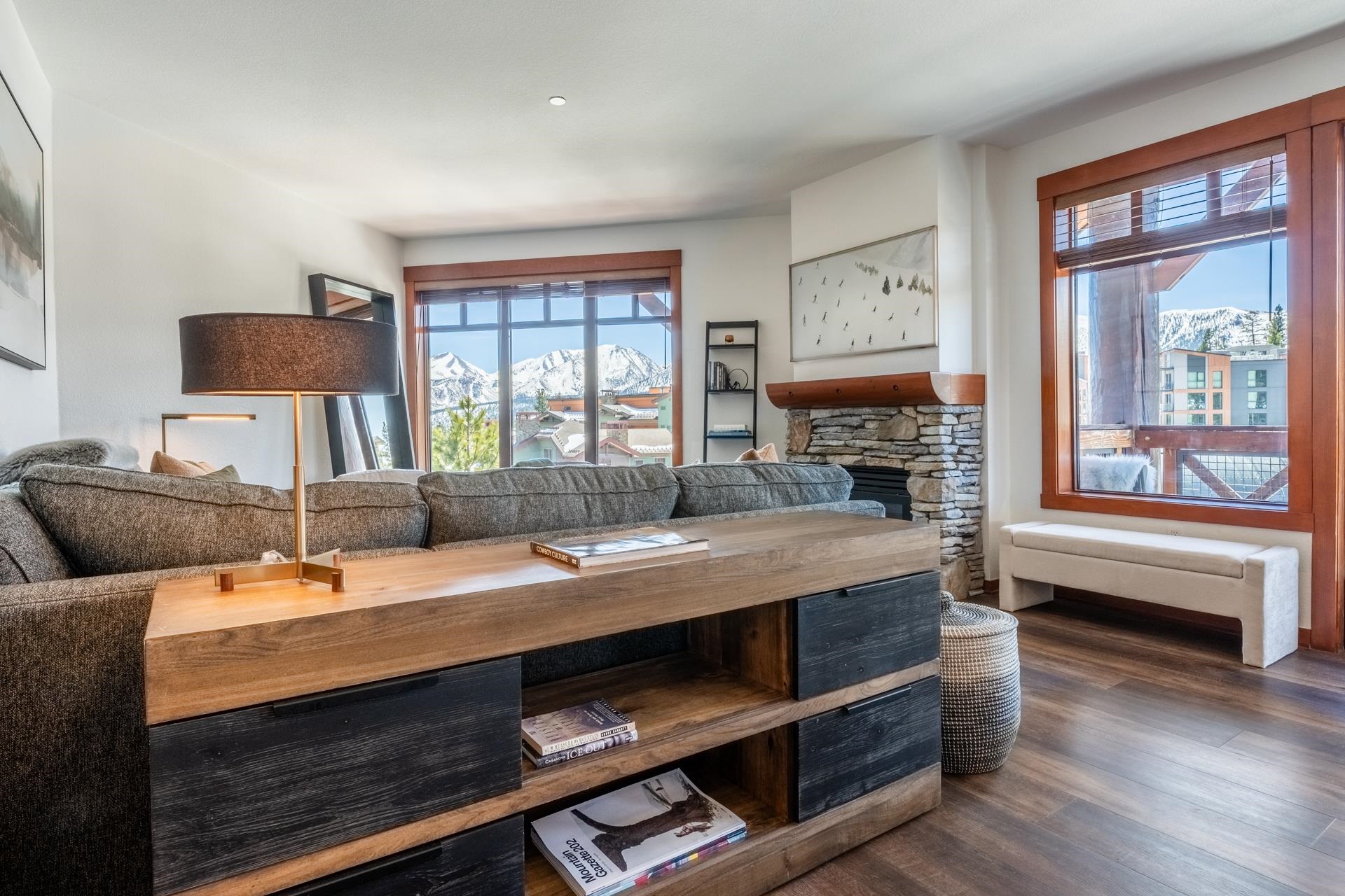 6201 Minaret Road, Unit 2430 Mammoth Lakes, CA 93546 - Photo 9 of 44 Living area featuring wood-finish flooring, a stone fireplace with a wood mantel, and large windows with wood trim