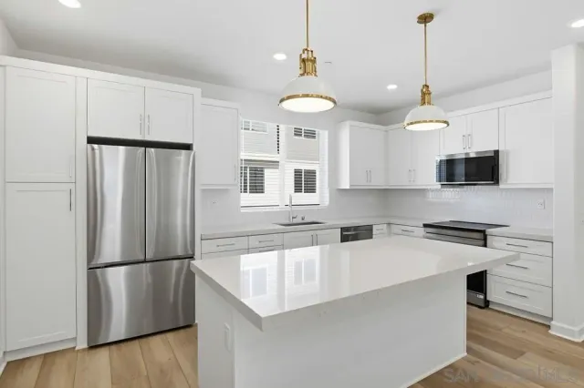 a kitchen with stainless steel appliances granite countertop white cabinets and a stove