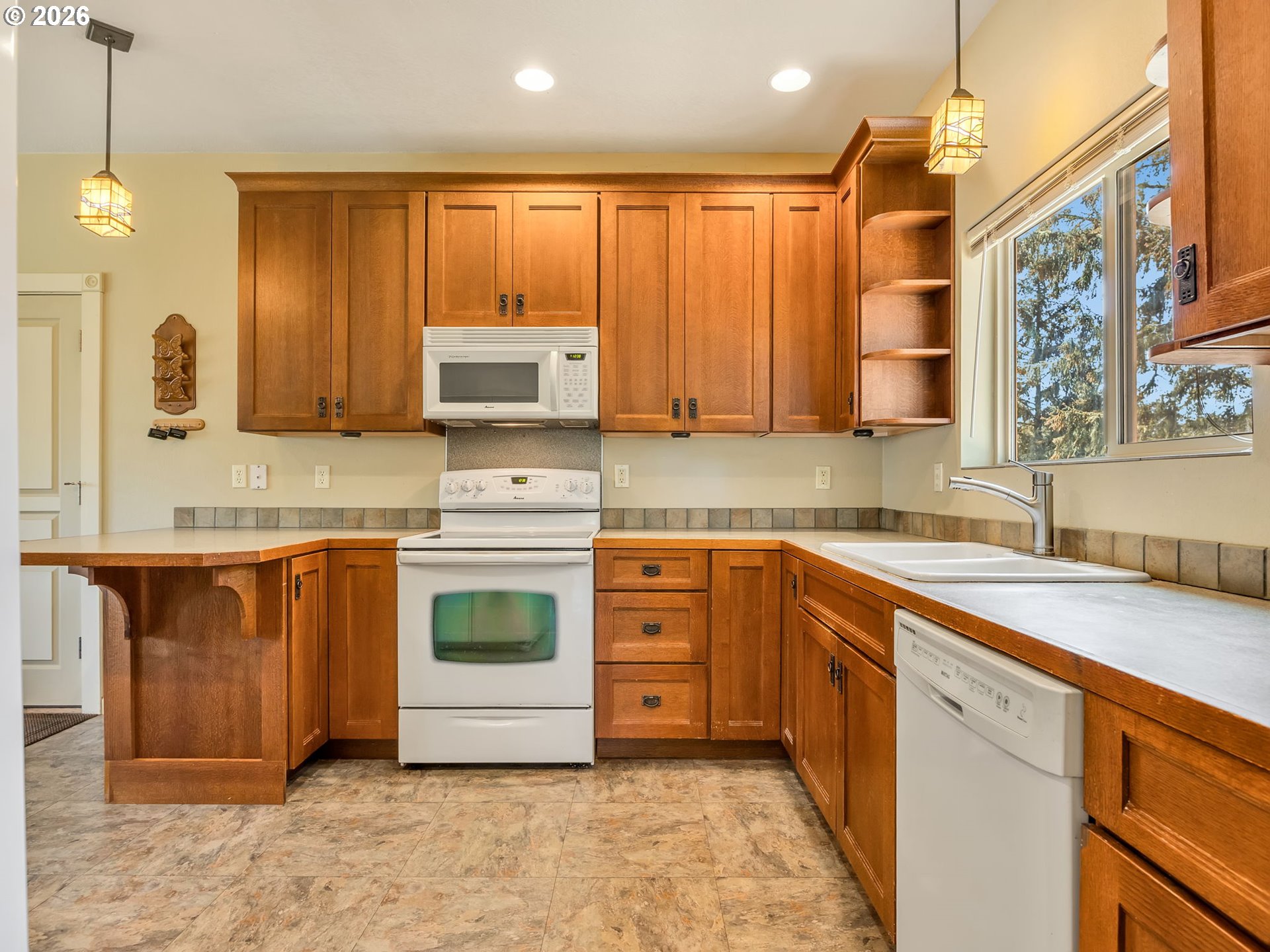 1077 Southwest Ridge Road Warrenton, OR 97146 - Photo 18 of 46 a kitchen with stainless steel appliances granite countertop a stove a sink and a microwave