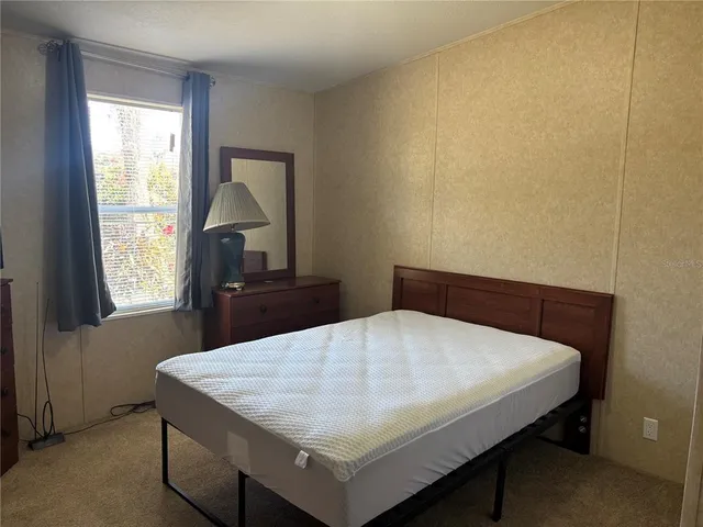 a bed sitting in a bedroom next to a window