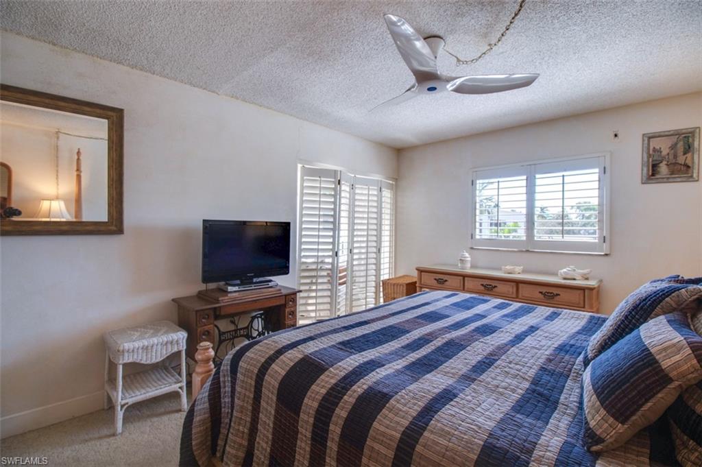 250 7th Avenue South, Unit 305 Naples, FL 34102 - Photo 11 of 24 a bedroom with a bed and a flat screen tv