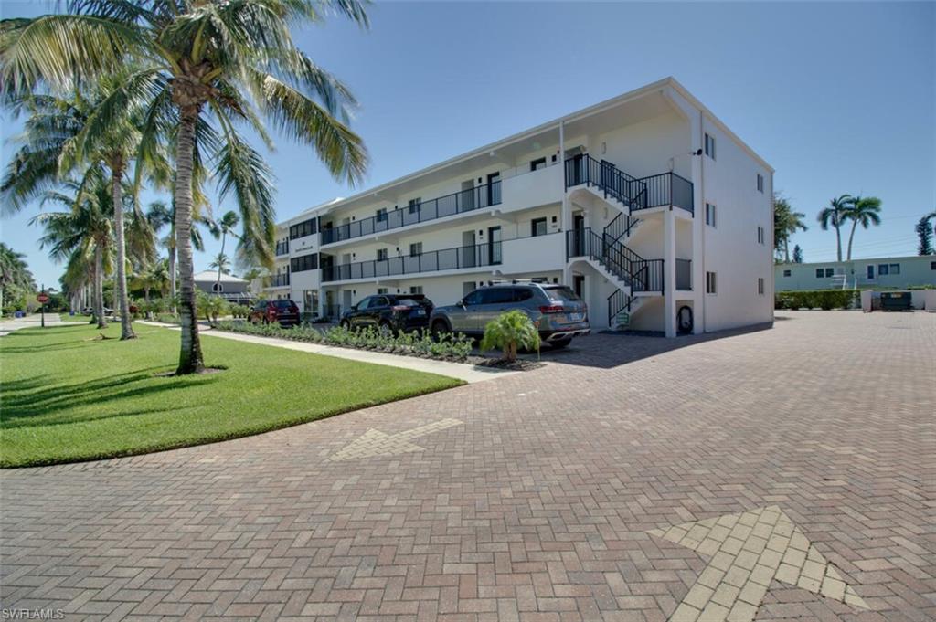 250 7th Avenue South, Unit 305 Naples, FL 34102 - Photo 19 of 24 a view of a building with a yard