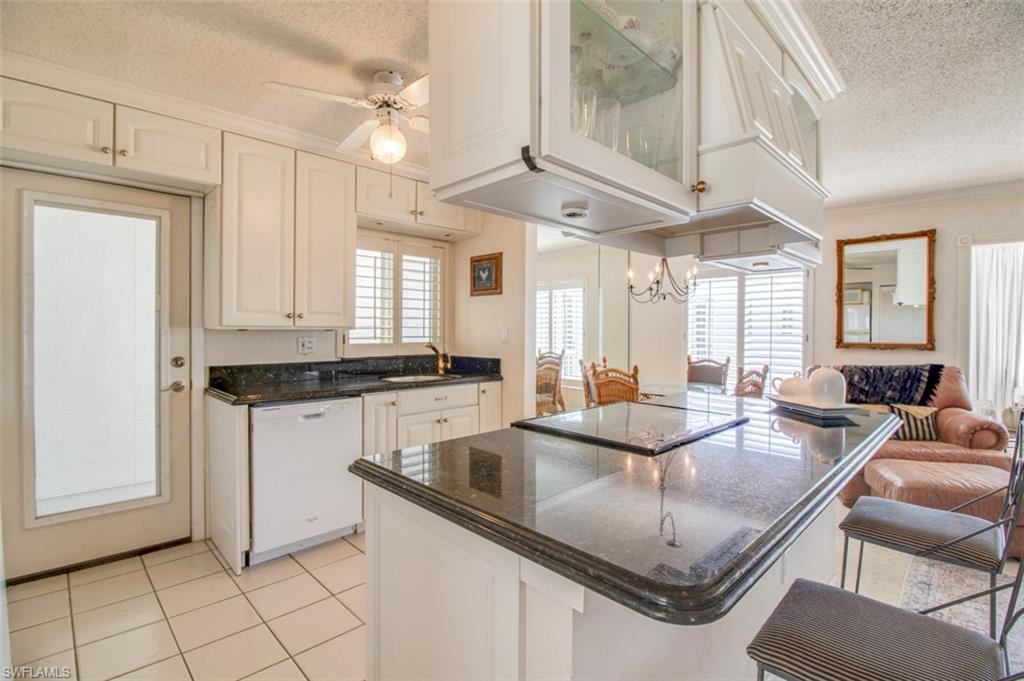 250 7th Avenue South, Unit 305 Naples, FL 34102 - Photo 3 of 24 a kitchen with center island table and chairs