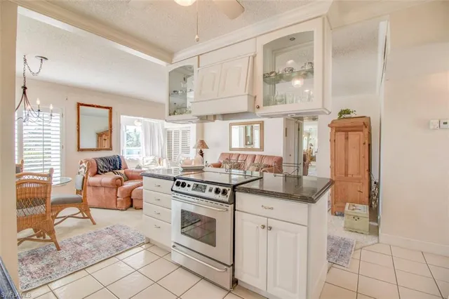 a kitchen with stainless steel appliances granite countertop a stove and white cabinets