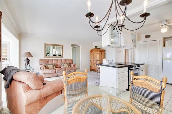 a living room with furniture a chandelier and a window