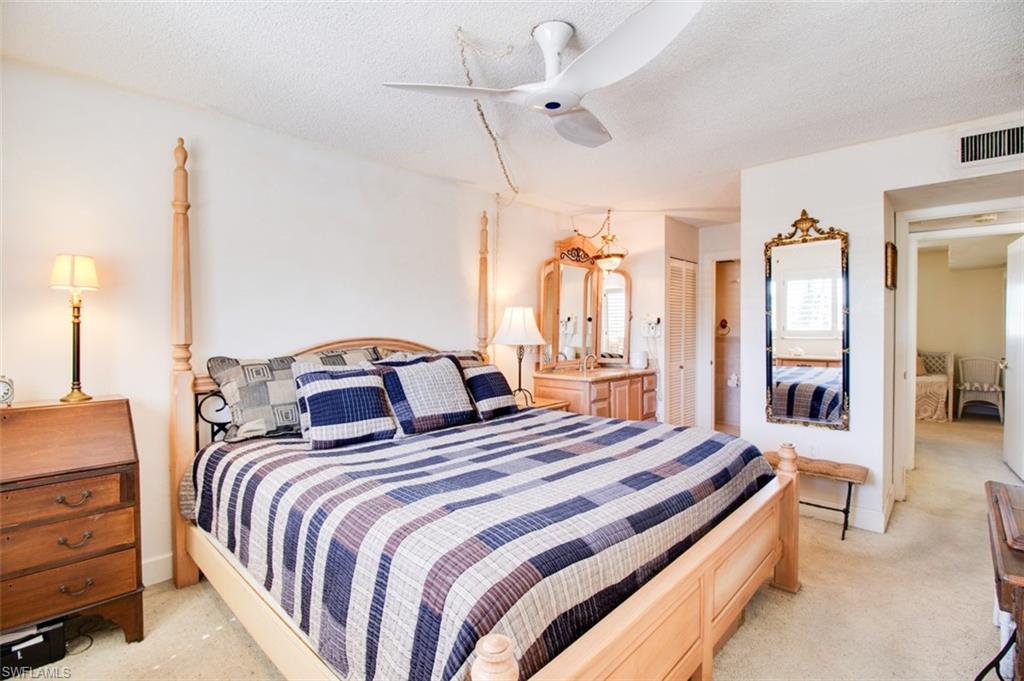 250 7th Avenue South, Unit 305 Naples, FL 34102 - Photo 9 of 24 a bedroom with bed and a chandelier