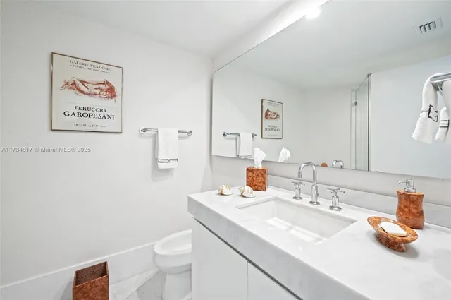 a bathroom with a sink toilet and a mirror