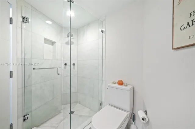 a bathroom with a toilet and a shower