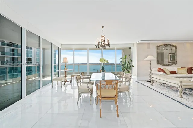 a living room with furniture a chandelier and a large window