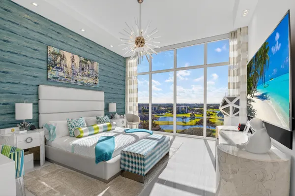a living room with furniture a flat screen tv and a floor to ceiling window