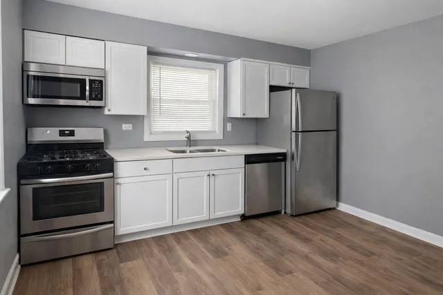 a kitchen with a sink a microwave a refrigerator and cabinets