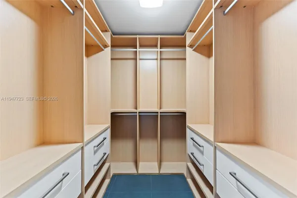a view of a hallway with closet and a window