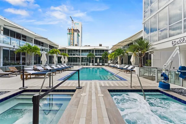a view of a building with sitting area and swimming pool