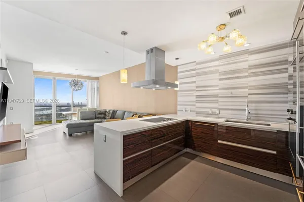 a kitchen view with wooden floor and stainless steel appliances