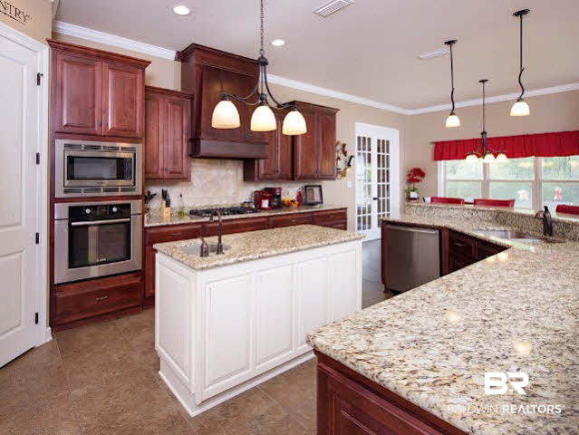 7814 Balin Drive Daphne, AL 36527 - Photo 4 of 26 Custom Kitchen with plenty of lighting and storage space, breakfast nook, breakfast bar, granite counter tops, multiple sinks, and stainless appliances for all your chef dreams!