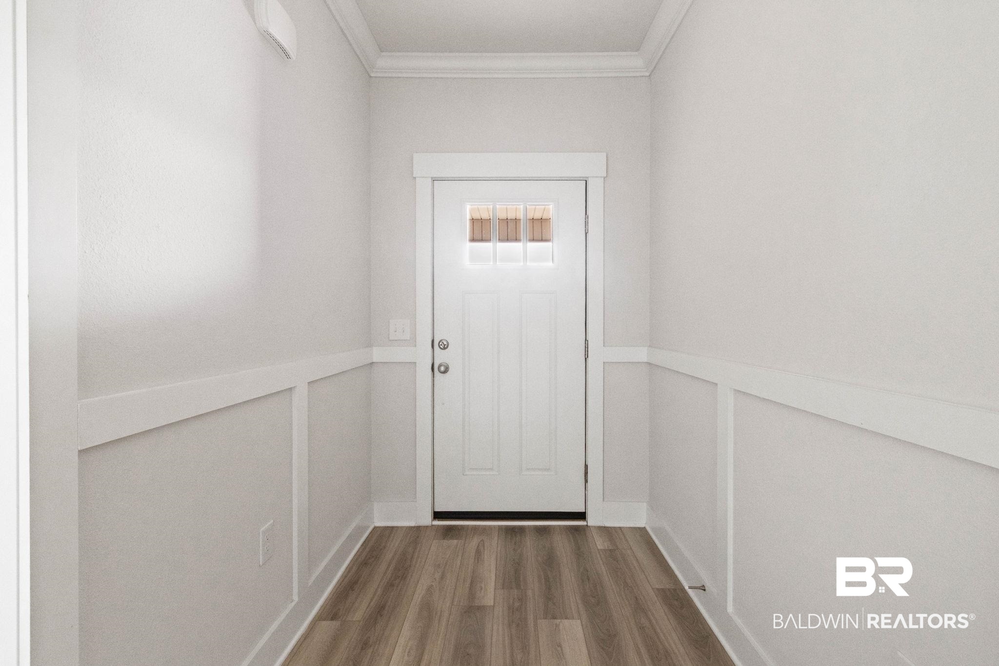 1710 Grouse Street Foley, AL 36535 - Photo 14 of 76 Entryway featuring a white paneled door with glass inserts, wood-finish flooring, wainscoting, white baseboards, and crown molding