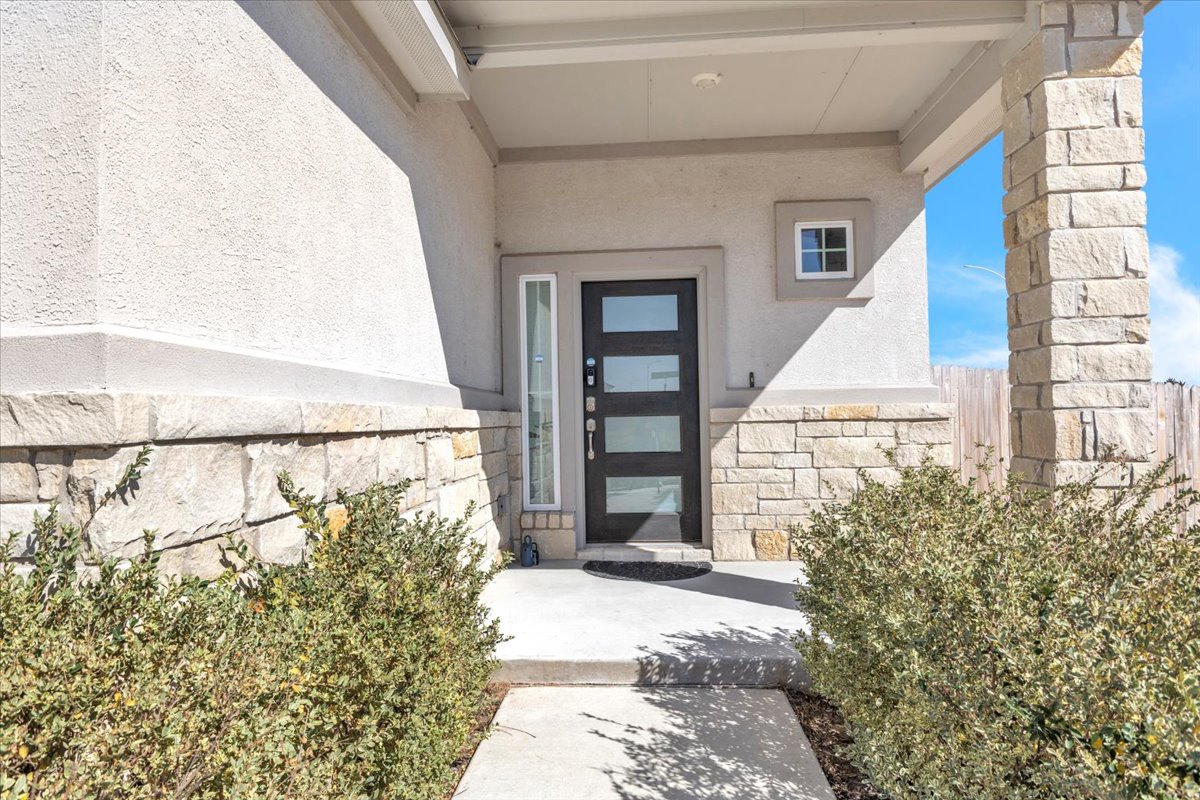 12620 Penguin Path Manor Manor, TX 78653 - Photo 2 of 37 Doorway to property featuring stone siding and stucco siding
