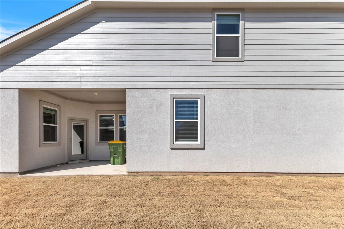 12620 Penguin Path Manor Manor, TX 78653 - Photo 30 of 37 Rear view of house with a lawn, a patio area, and stucco siding