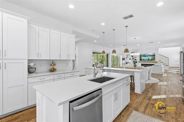 a kitchen with stainless steel appliances granite countertop a sink a stove and cabinets