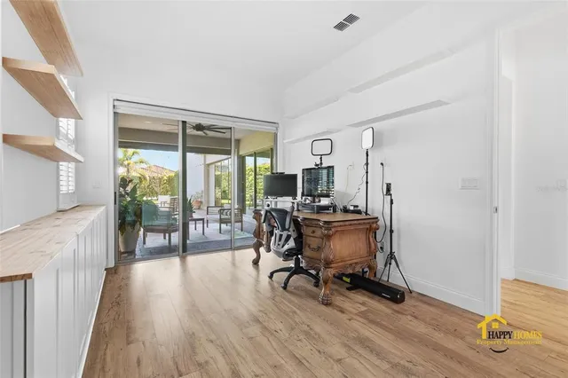 a room with white cabinets and clock on the wall