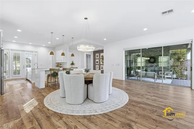 a kitchen with stainless steel appliances kitchen island granite countertop a sink cabinets and wooden floor
