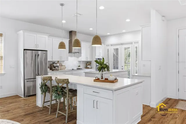 a large kitchen with stainless steel appliances granite countertop a lot of counter space and wooden floors