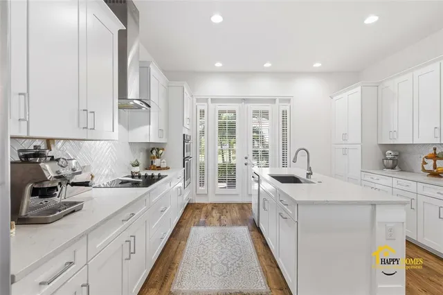a kitchen with kitchen island granite countertop a sink a counter space appliances and cabinets