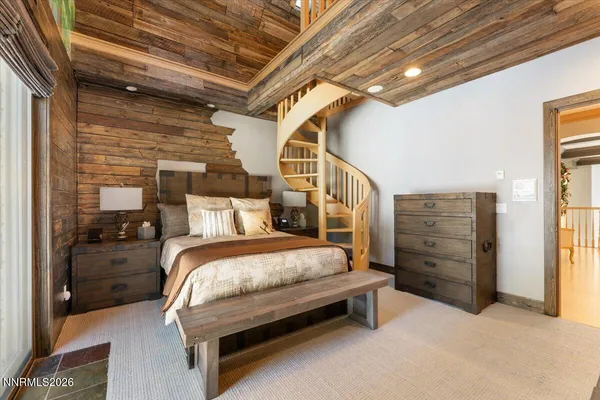 a bedroom with a bed couch and a large window