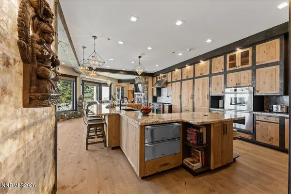a dining hall with stainless steel appliances kitchen island granite countertop a stove and cabinets