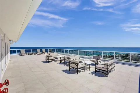 a roof deck with a table and chairs with wooden floor