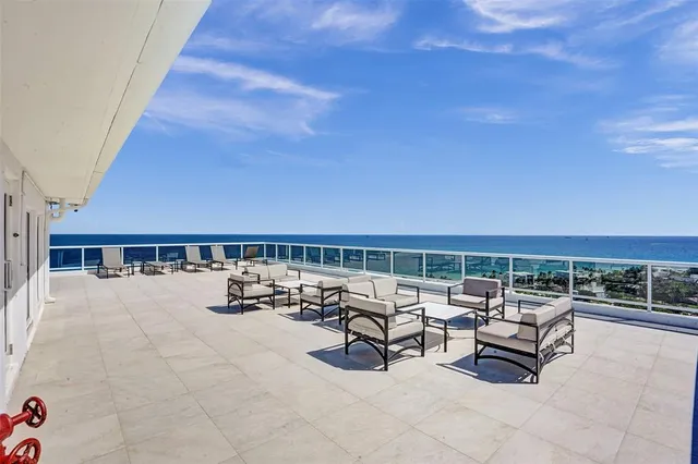 a roof deck with a table and chairs with wooden floor