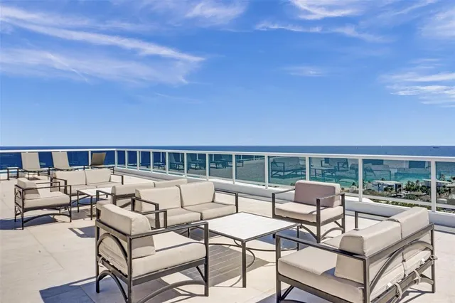 a roof deck with couches and potted plants