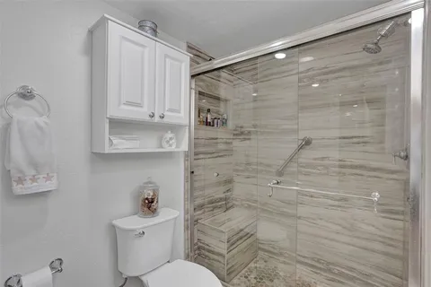 a bathroom with a shower a toilet and a sink