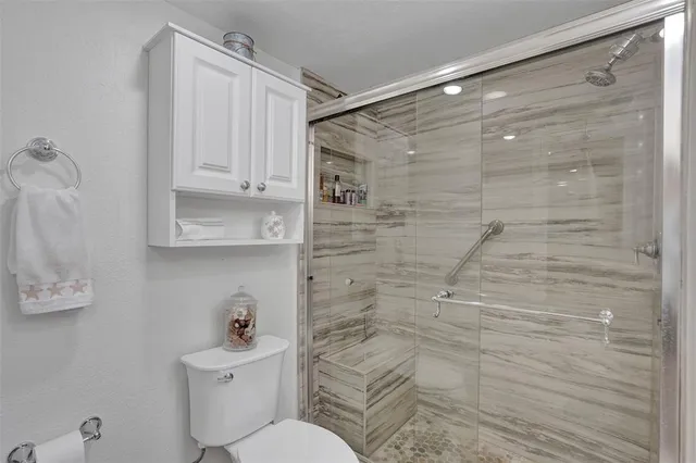 a bathroom with a shower a toilet and a sink