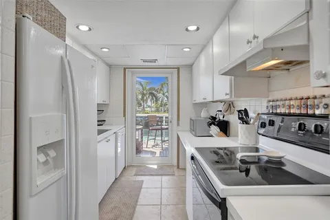 a kitchen with stainless steel appliances granite countertop a refrigerator a sink and a stove