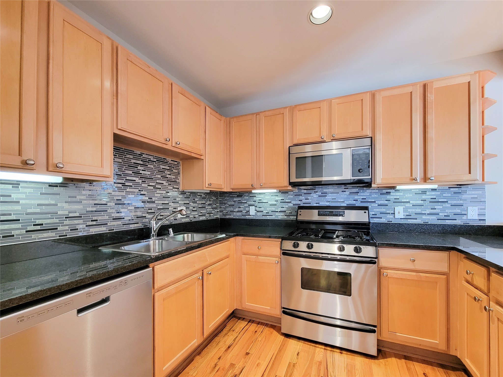 2520 Robinhood Street, Unit 800 Houston, TX 77005 - Photo 11 of 46 a kitchen with granite countertop a sink cabinets stainless steel appliances and a counter space