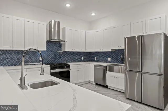 a kitchen with white cabinets and stainless steel appliances