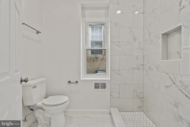 a bathroom with a toilet and a shower