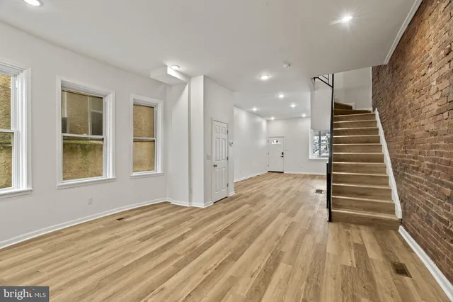 a view of a room with wooden floor and windows