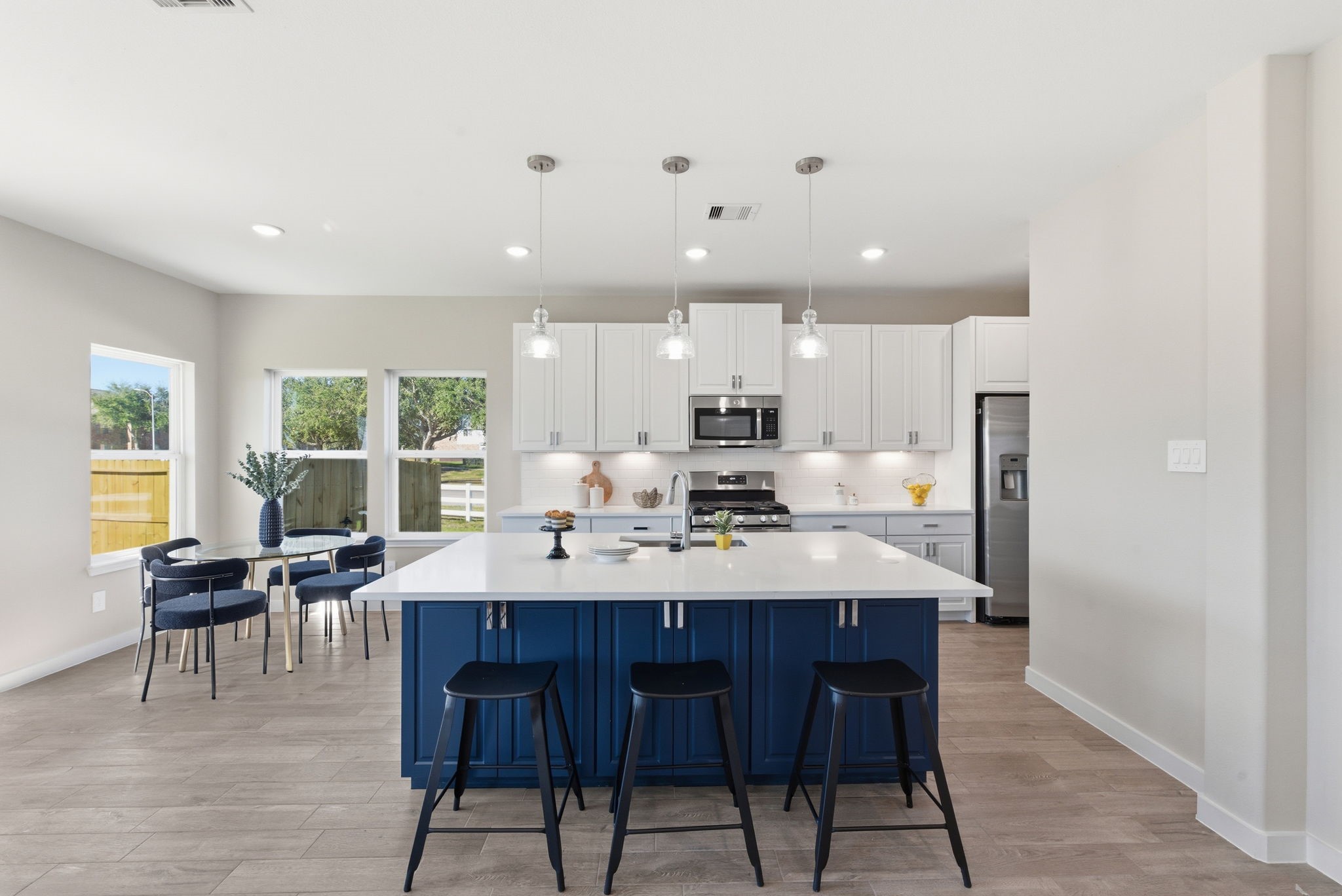 2443 Inlet Court Fresno, TX 77545 - Photo 14 of 50 a large kitchen with kitchen island a dining table and chairs