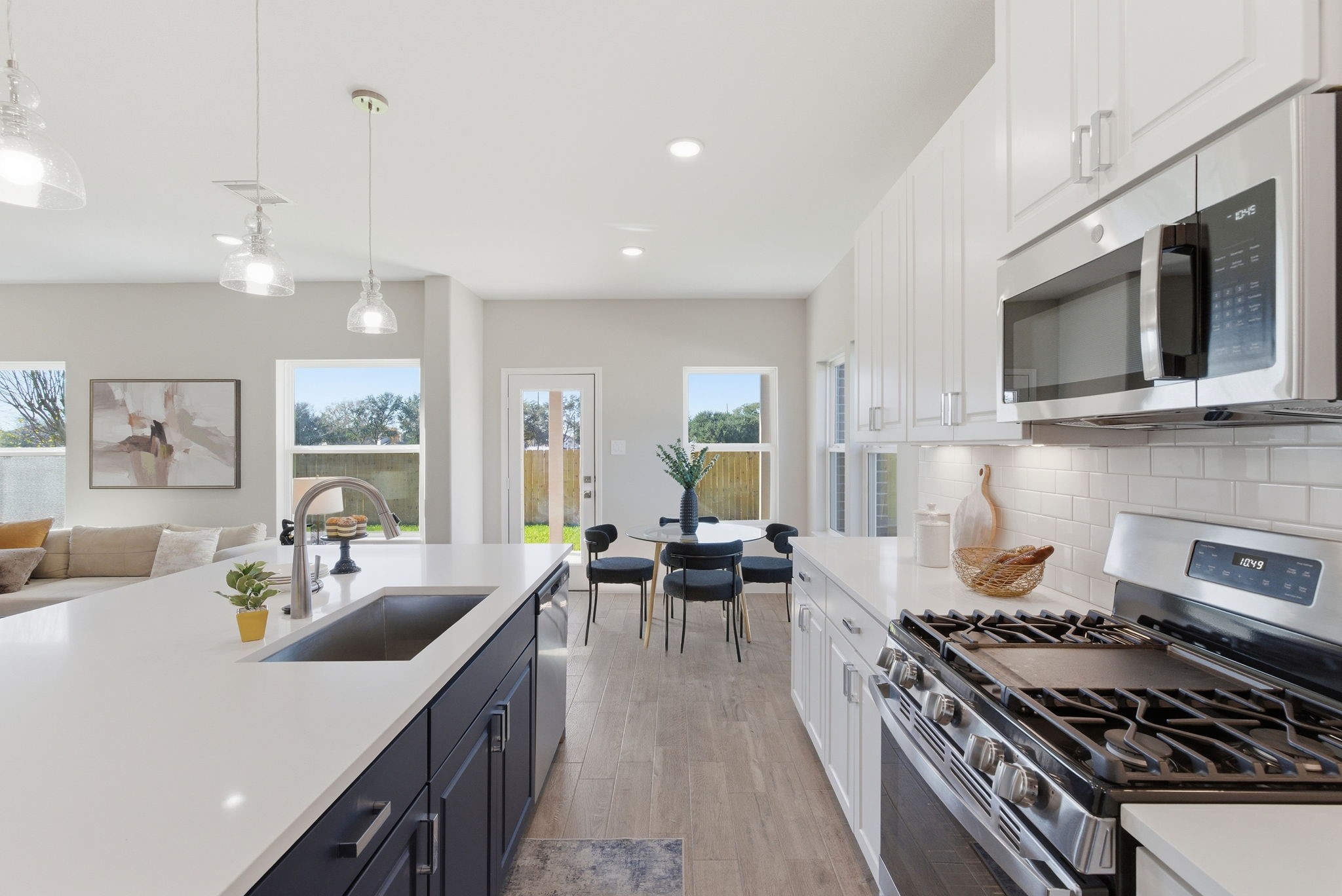 2443 Inlet Court Fresno, TX 77545 - Photo 18 of 50 a kitchen with stainless steel appliances granite countertop a stove top oven a sink dishwasher and white cabinets with wooden floor