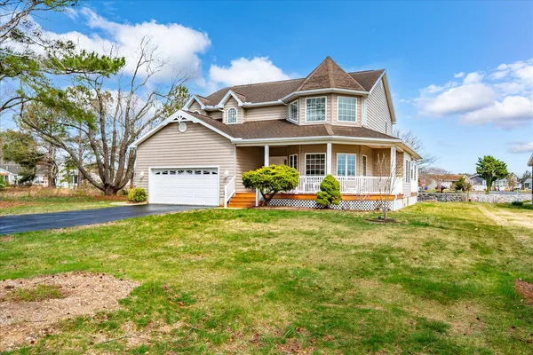 a view of a house with table and chairs under an umbrella