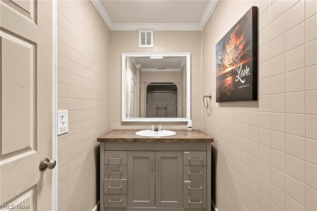1875 Perth Road Madison, OH 44057 - Photo 17 of 48 Built-in vanity with an integrated sink, a rectangular mirror, and a stone-finish countertop