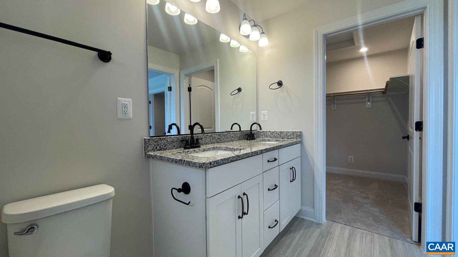 4006 Varick Street Charlottesville, VA 22901 - Photo 21 of 33 a bathroom with a granite countertop sink a toilet and shower